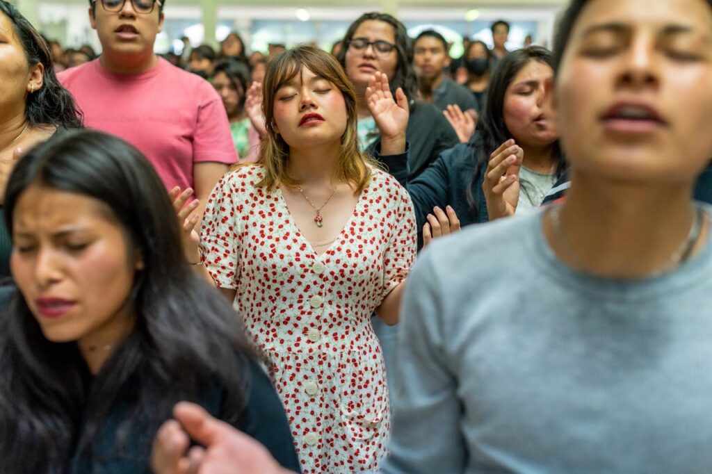 A group of people in a room with their hands raised